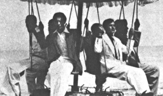 メリー・ゴーランドに6人の男を乗せ、これを腹の上で支えるというカわざを見せるシャイク博士