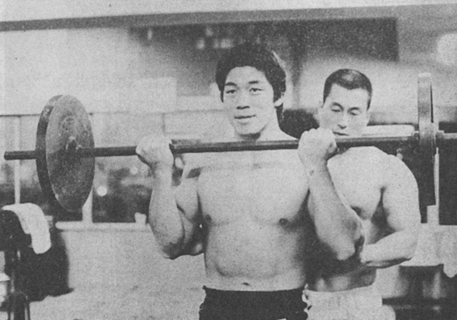 [バーベル・カールをする小沼選手。うしろが加藤利雄選手]