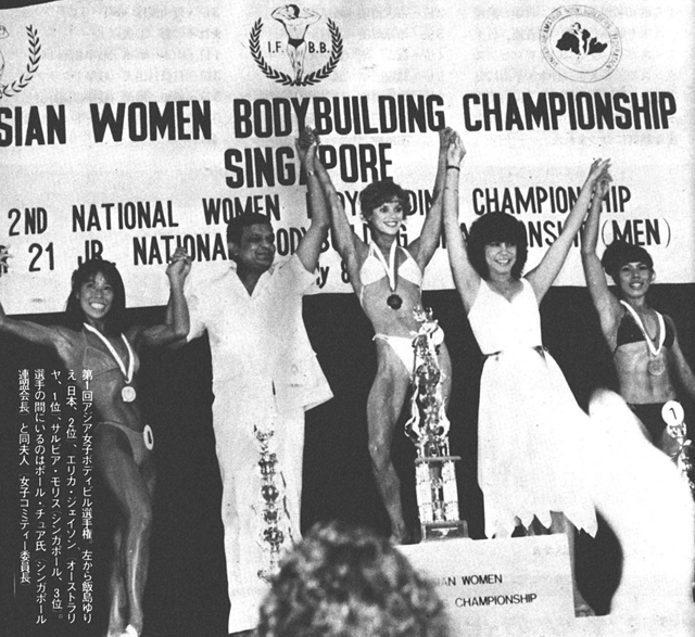 第1回アジア女子ボディビル選手権。左から飯島ゆりえ(日本、2位)、エリカ・ジェイソン(オーストラリヤ、1位)、サルビア・モリス(シンガポール、3位)。選手の間にいるのはポール・チュア氏(シンガポール連盟会長)と同夫人(女子コミティー委員長)