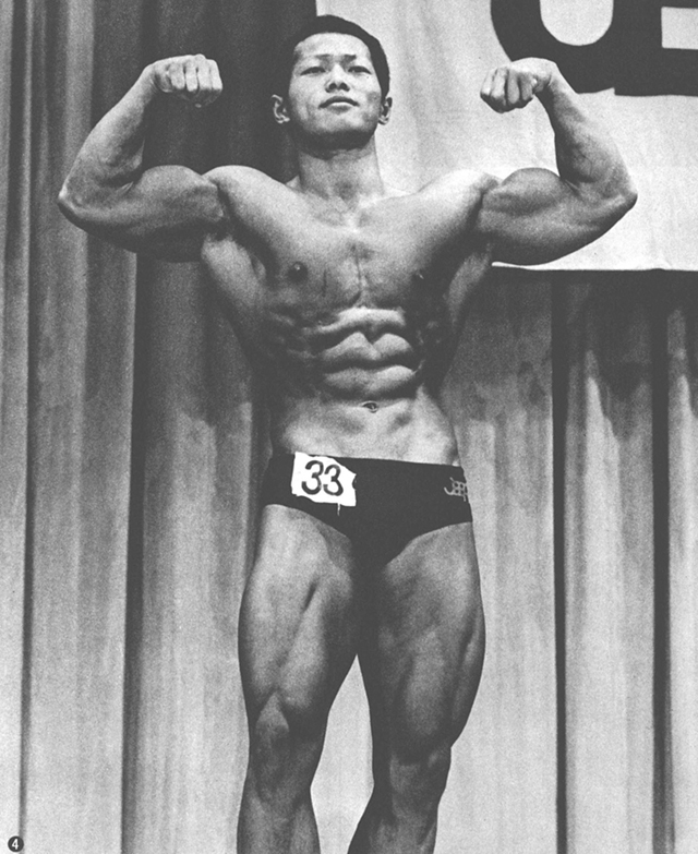 ④前の写真があまりにもよかっただけに、このダフル・バイセップスのポーズは迫力がない。腹直筋と前鋸筋の発達は十分に誇示されているが、大胸筋の厚みが全く感じられないのが残念だ。この筋のトレーニングが急務なのかも知れない。